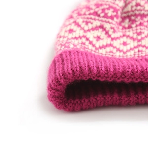 Macro shot of pink and cream jacquard knit hat with thick ribbed cuff and soft texture