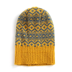 Women's knit beanie with yellow and blue Fair Isle diamond pattern and pom-pom detail