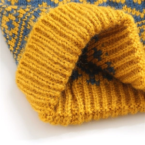 Close-up of yellow and navy knit beanie with diamond pattern and thick ribbed texture