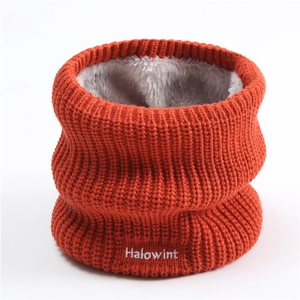 Close-up of orange knitted neck warmer with white embroidered text and plush lining