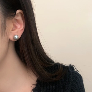Detail of vintage grey pearl stud earring on model showing metallic luster and round shape
