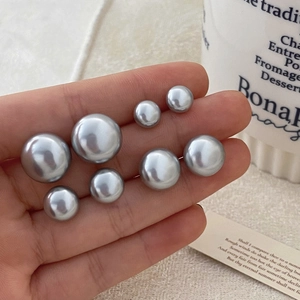 French vintage grey pearl earrings set in various sizes held in hand for scale