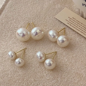 Detailed view of colorful pearl studs in large and small sizes on beige fabric