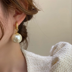 Detail of French vintage pearl earrings with 18k gold plating on model side profile