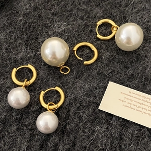 French vintage 18k gold earrings set with round white pearls on dark knit texture