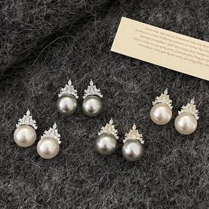 Elegant crown-shaped pearl stud earrings with micro-set zircons on a knit background