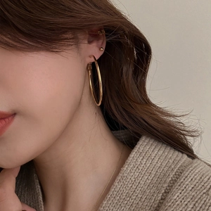 Minimalistische goldene Creolen mit Stecker und Ohrmanschette am Modell
