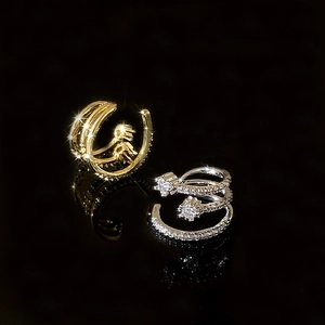 Macro shot of gold and silver multi-layer spiral ear cuffs with sparkling micro-pave zircons