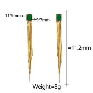 Macro view of gold tassel earrings with green emerald-cut gemstones and size details