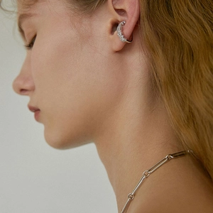 Gros plan d'une bague d'oreille argentée avec cristaux portés sur le cartilage