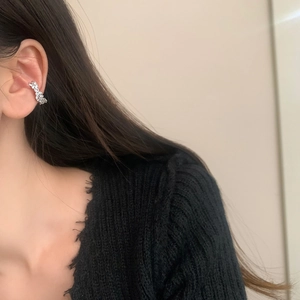 Gros plan d'un ear cuff argenté avec zircons marquise porté par un mannequin