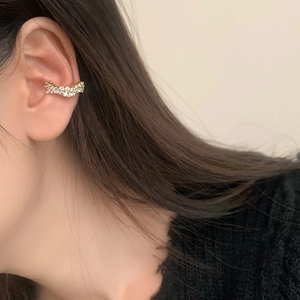Vue détaillée de la manchette d'oreille dorée ondulée avec double rangée de cristaux