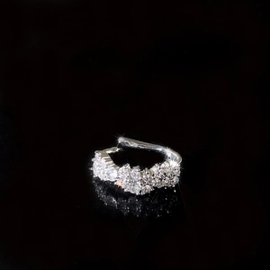 Détail d'une boucle d'oreille manchette argentée ornée de zircons brillants en pavé