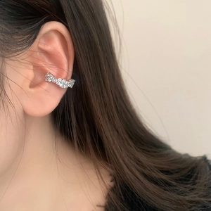 Gros plan sur l'oreille d'un ear cuff en argent minimaliste serti de zircons