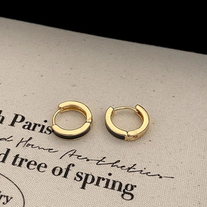 Detailed close-up of French style gold-tone hoop earrings with black enamel oil drip finish