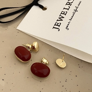 Detail view of vintage burgundy oval drop earrings with elegant gold metal frames