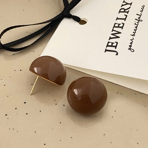 Detailed view of glossy dark brown dome earrings on a premium jewelry display tray