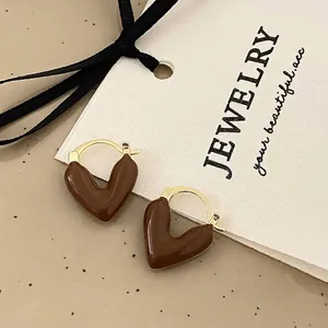 Macro detail of French vintage heart earrings with brown enamel and golden metal