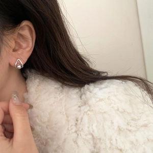 Close-up of elegant silver teardrop earrings with grey pearl on model's ear