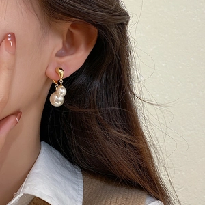 Elegant gold drop earrings with double white pearls on model for a sophisticated look