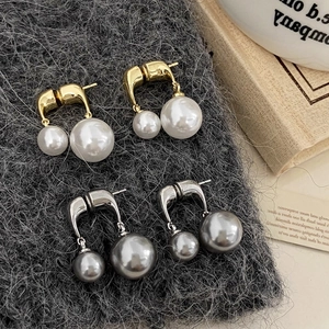 Detail of luxury pearl drop earrings with U-shaped metal hooks in gold and silver plating