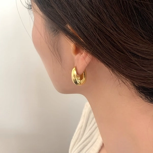 Polished gold chunky hoop earrings shown on a model for a modern minimalist jewelry look