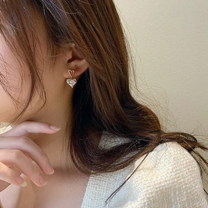 Gros plan de boucles d'oreilles double cœur élégantes avec gemmes roses et or