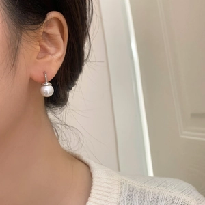 Elegant silver pearl earrings with 10mm white round pearl worn on ear with sweater