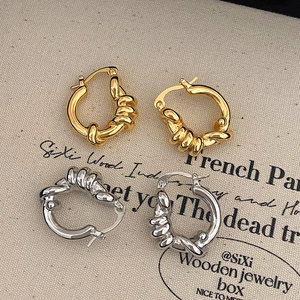 Orecchini a cerchio intrecciati in oro e argento con design a nodo minimalista