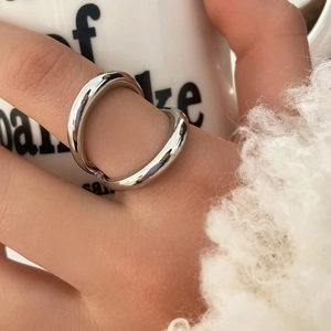Polished silver minimalist ring worn by a model against a soft white background