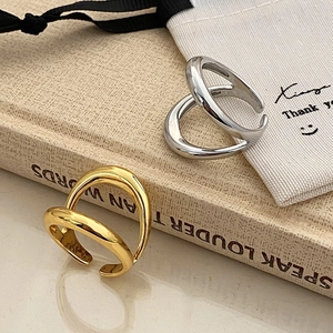 Detailed view of intertwined gold and silver open rings with high-polish metallic finish
