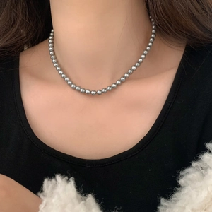 Détail macro d'un collier de perles grises élégantes au fini métallique brillant