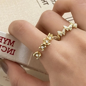 Adjustable gold butterfly and flower rings with white enamel and sparkling zircons