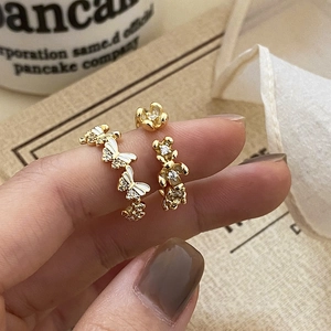 Detail of adjustable gold ring featuring white enamel butterflies and bear with crystals