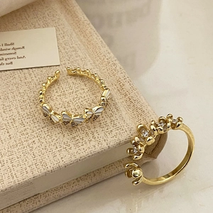 Adjustable golden rings with butterfly and flower designs in white enamel and crystals