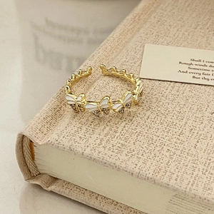 Close-up of gold-plated open ring with white enamel butterflies and sparkling zircons
