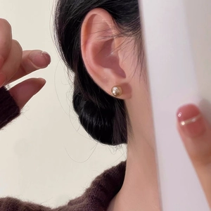 Eleganti orecchini a perno con perle color champagne in stile retrò indossati da una modella