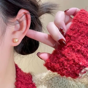 Minimalist gold round ball stud earrings with polished finish shown on a female model