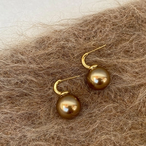 Elegant retro bronze pearl earrings with gold-plated hooks on a soft wool background