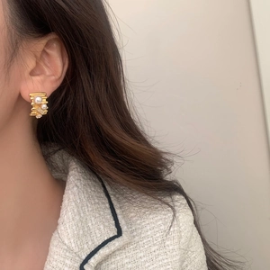 Elegant gold-plated tiered earrings with pearls and cubic zirconia on female model
