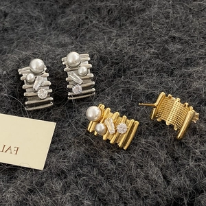 Elegant gold and silver rectangle stud earrings with pearls and zircon on gray fabric