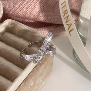 Macro shot of silver bow ring with pave-set zircon crystals on a velvet jewelry gift box