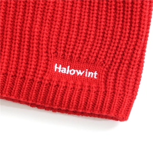 Macro shot of red knitted scarf fabric with high-quality Halowint white letter embroidery