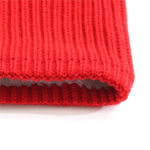 Detail of red cable knit neck warmer featuring thick gray fleece lining for winter warmth