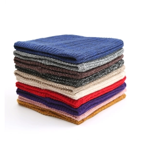 Close-up of cable knit winter neck warmers in multiple colors with ribbed texture detail