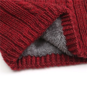 Detail of burgundy cable knit fabric and thick grey fleece lining for warmth