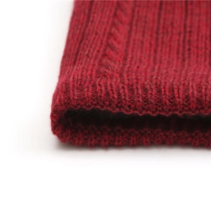 Detailed close-up of dark red ribbed knit texture on a thick winter infinity scarf