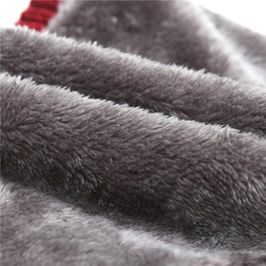Macro shot of thick dark gray faux fur lining and red knitted fabric of winter scarf