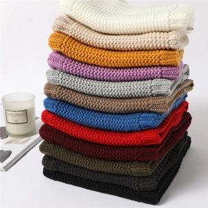 Detail showing various colors of cable knit scarves with soft texture and warm lining