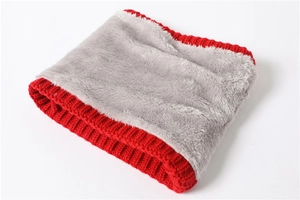 Detail of red cable knit exterior and thick gray fleece lining on a warm winter neck gaiter